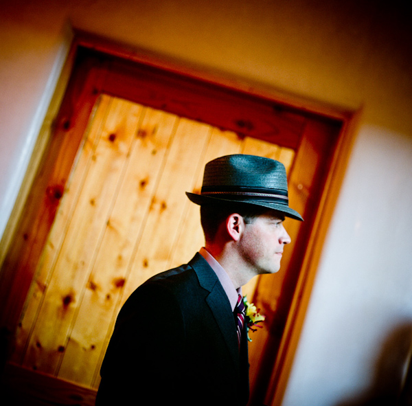 image of the handsome groom wearing a gray fedora with a black and purple border - photo by New Mexico based wedding photographers Twin Lens